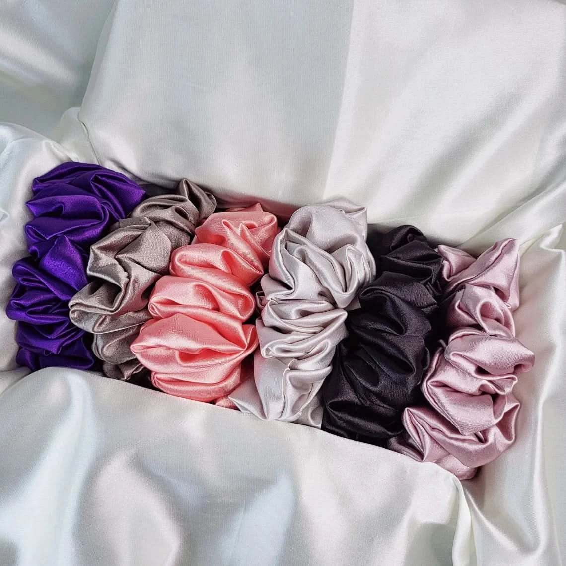 Set of colorful scrunchies on a white fabric background
