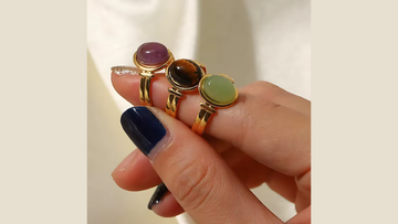 Stacked gold rings styled on fingers