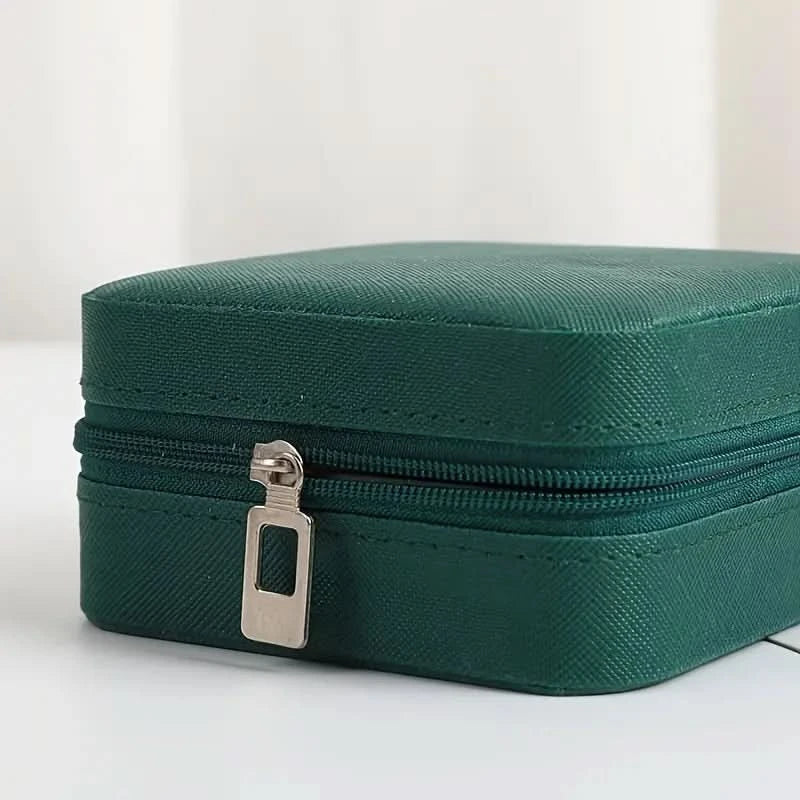 Green jewelry box with a silver zipper on a white background