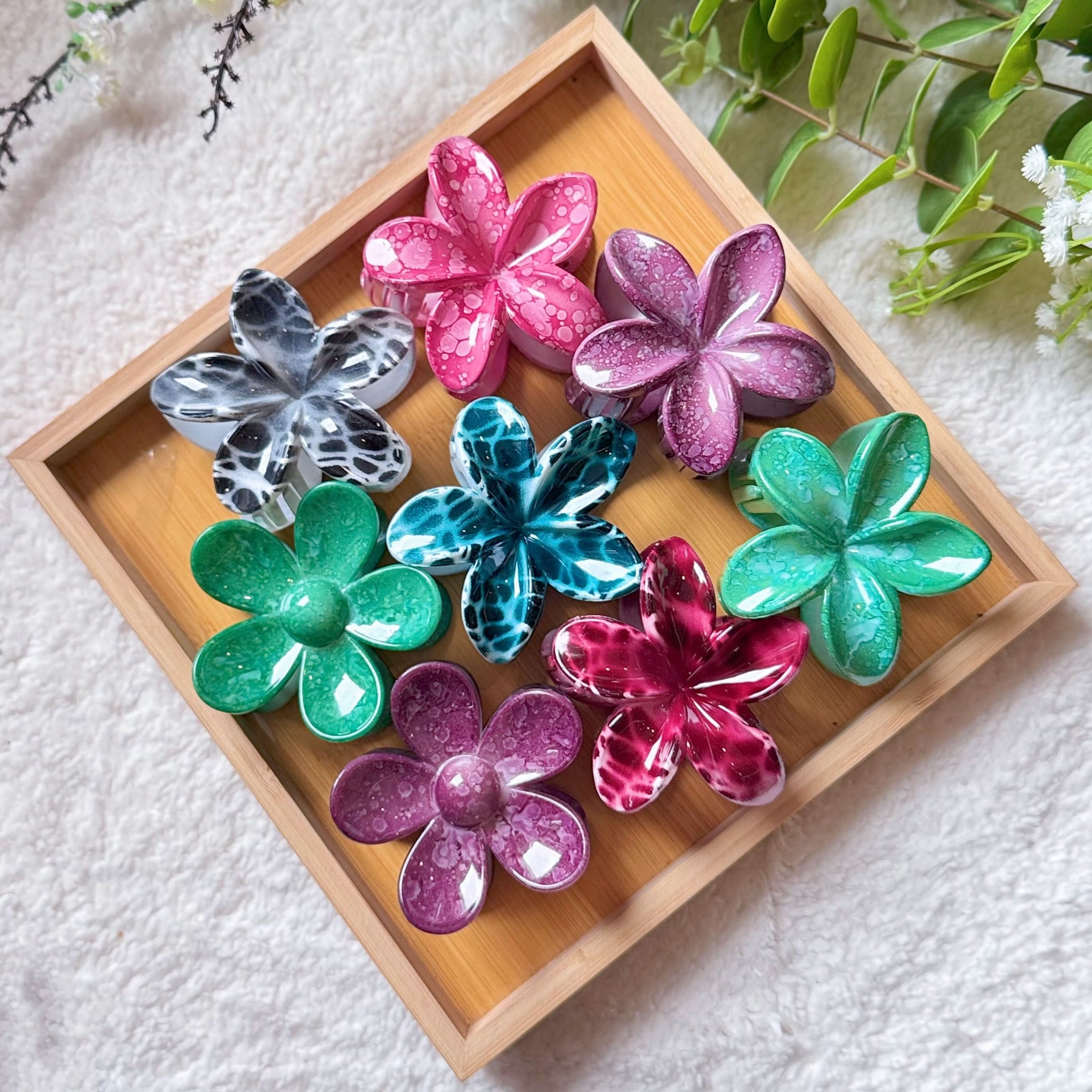 Colorful flower-shaped objects on a wooden tray with a white background