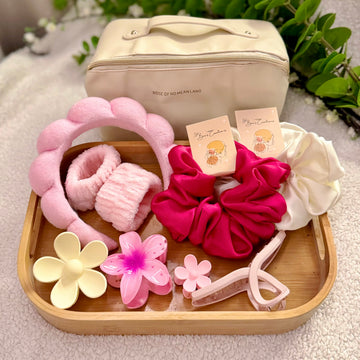 Set of hair accessories including scrunchies, headbands, and clips on a wooden tray with a beige bag in the background.
