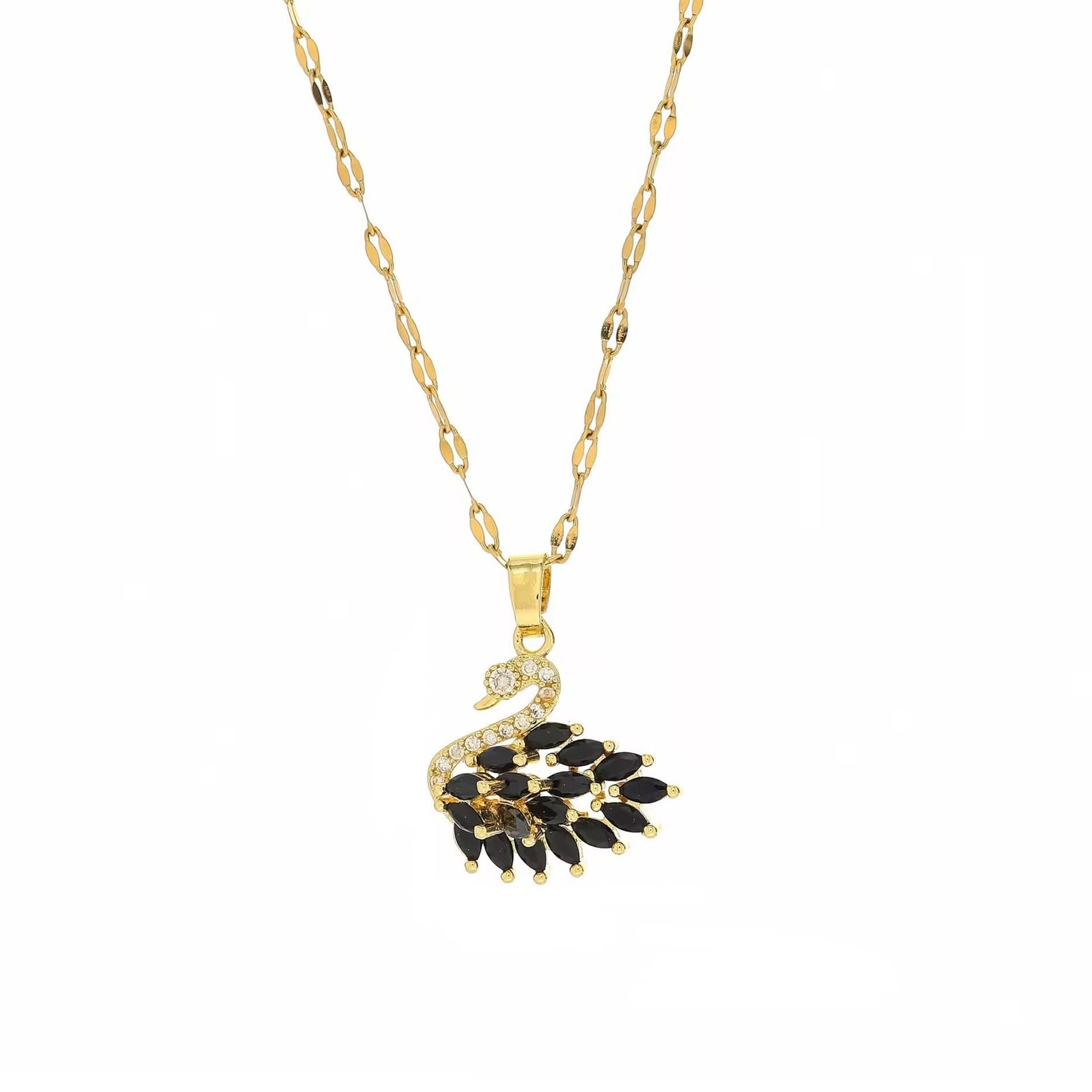 Gold necklace with a black and gold leaf-shaped pendant on a white background