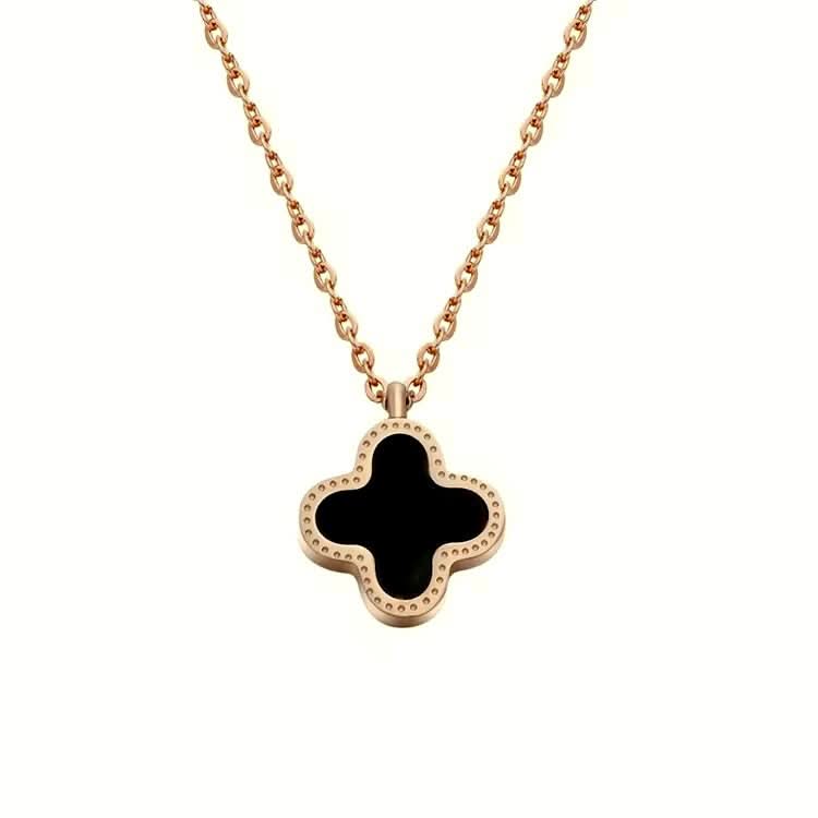 van cleef gold necklace with a black clover pendant on a white background