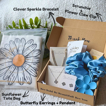 Gift box with sunflower tote bag, butterfly earrings, necklace, scrunchies, and bracelet on a white background.