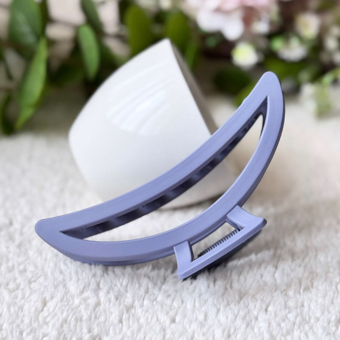 Purple hair clip on a textured surface with a blurred background