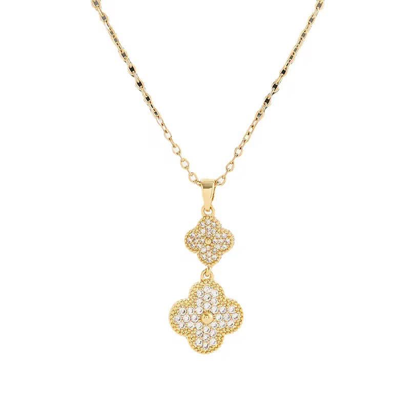 Gold necklace with a clover-shaped pendant on a white background