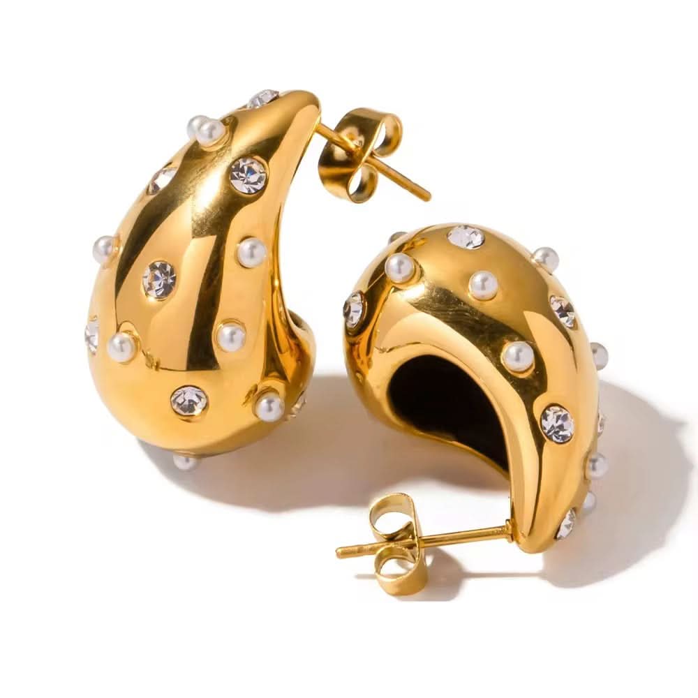 Gold earrings with pearl and crystal embellishments on a white background