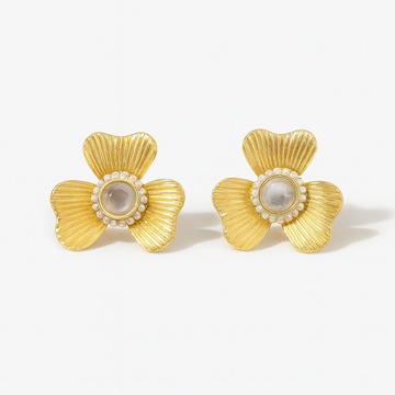 Pair of gold earrings with pearl center on a white background