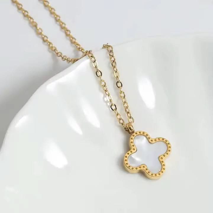 Gold necklace with a butterfly-shaped pendant on a white background