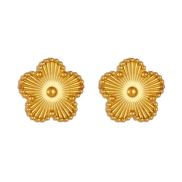 Pair of gold flower-shaped earrings on a white background