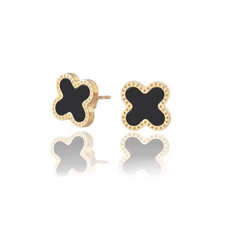 Pair of gold earrings with black center on a white background