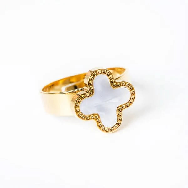 Van Cleef Gold ring with a white stone on a white background