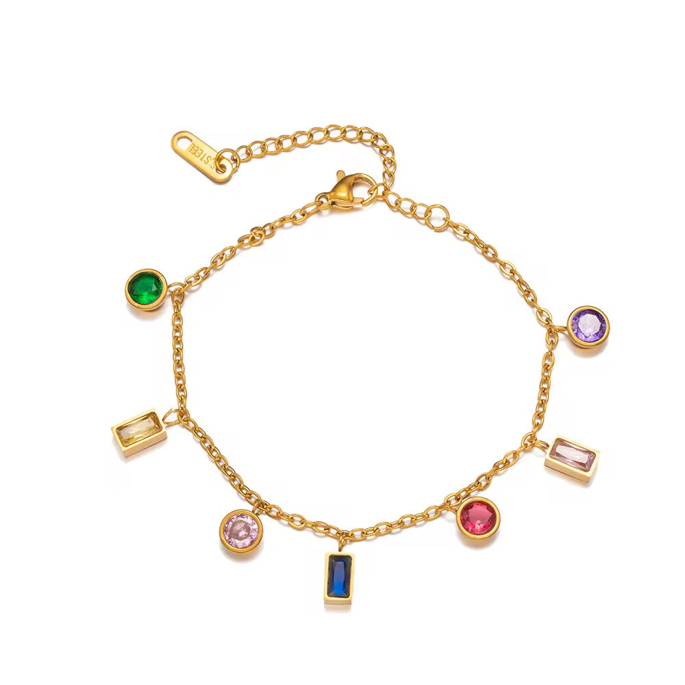 Gold bracelet with colorful gemstone charms on a white background