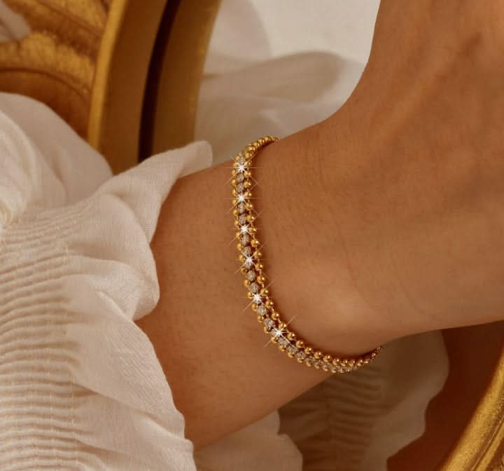 Gold bracelet on a wrist with a blurred background