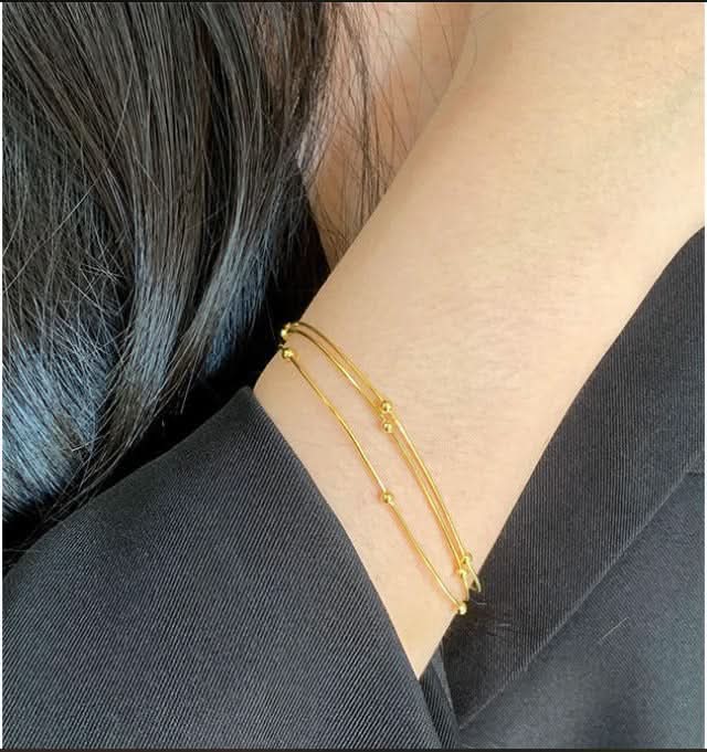 Gold bracelet on a person's wrist with a blurred background