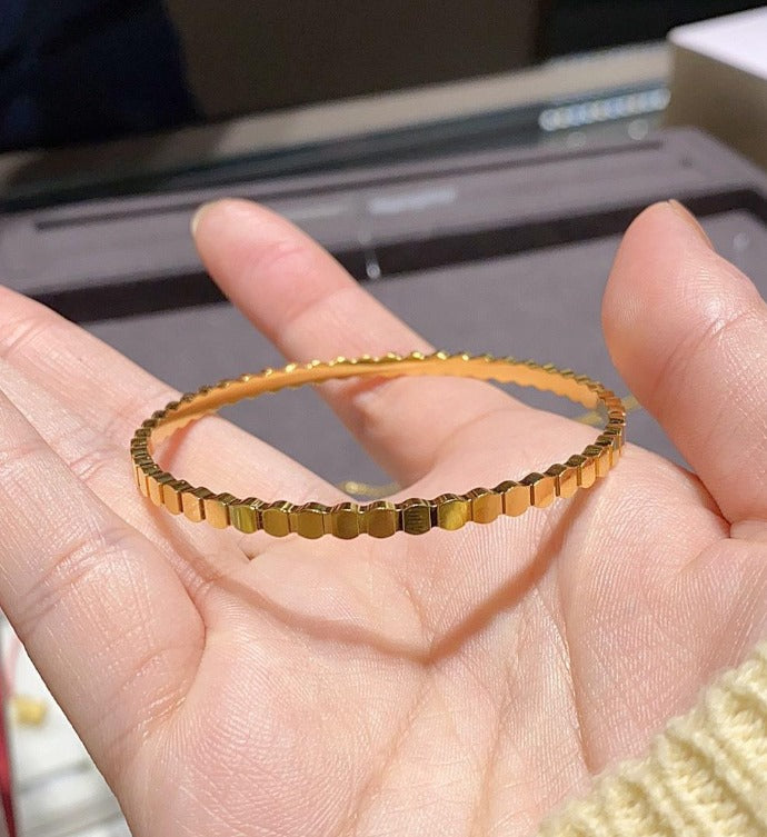 Gold bracelet on a hand with a blurred background