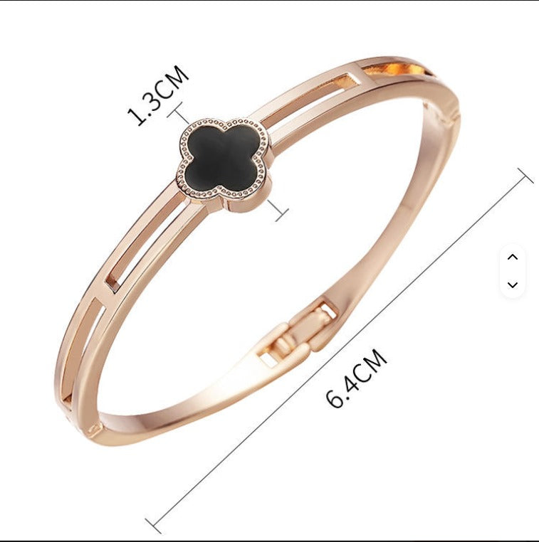 Rose gold bracelet with a black clover-shaped center and measurements on a white background
